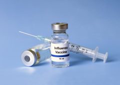 vial of flu vaccine and a needle