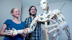 Two grad students with a "human" robot