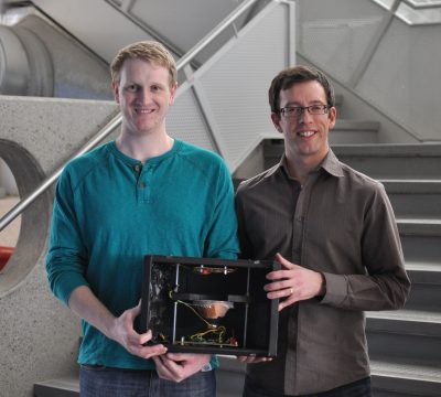 Alex and Ryan holding the Radon Monitor, which the sensor goes into