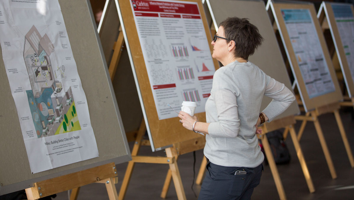 a person looks at several data day student posters